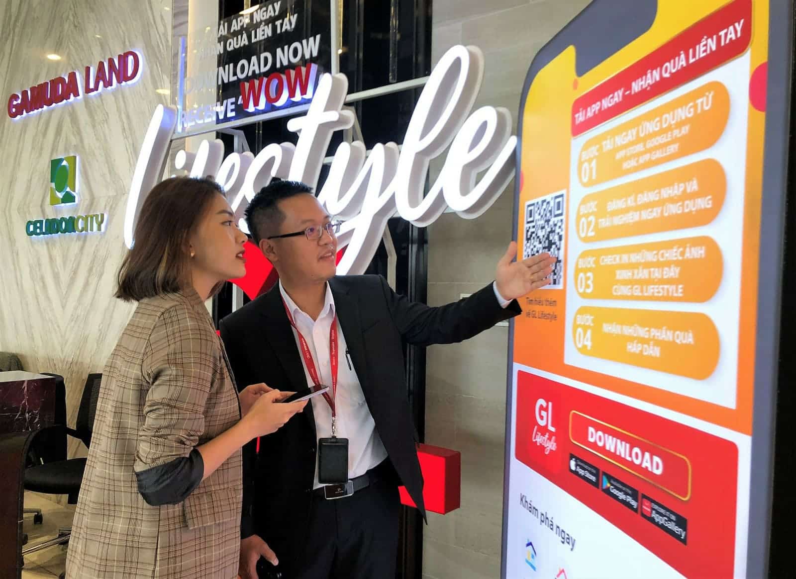 Nhân viên tư vấn đang hướng dẫn khách hảng tải ứng dụng GL Lifestyle. Ảnh: Gamuda Land.